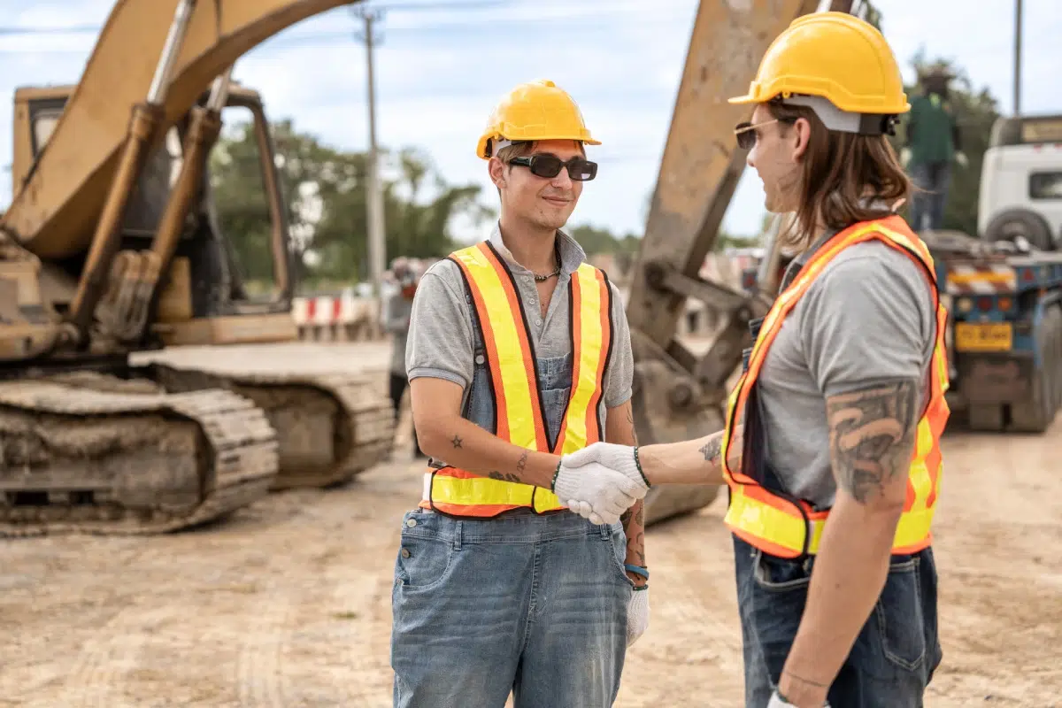 construction workers shaking hands on a job site